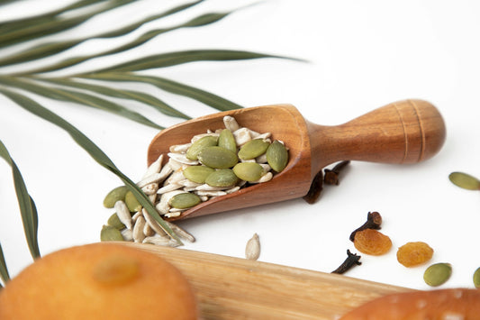a wooden spoon filled with nuts and seeds