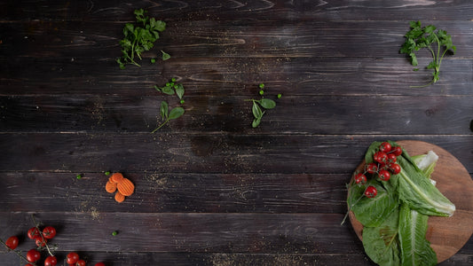 a cutting board topped with lettuce next to carrots and radishes