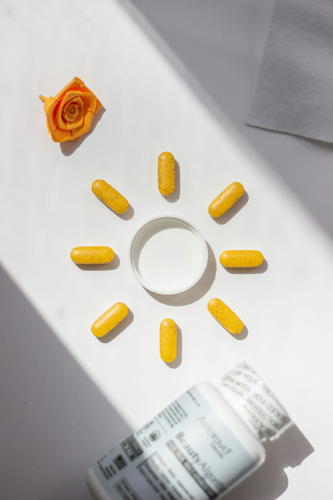 A bottle of pills and a rose on a table
