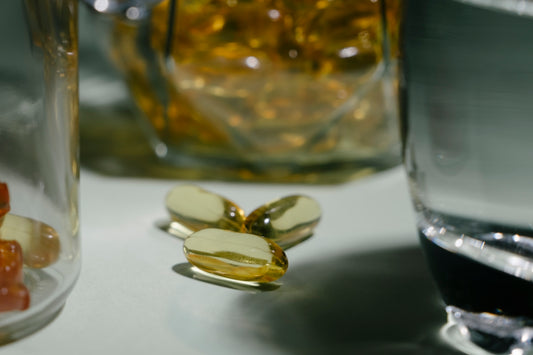 A glass of water and some pills on a table