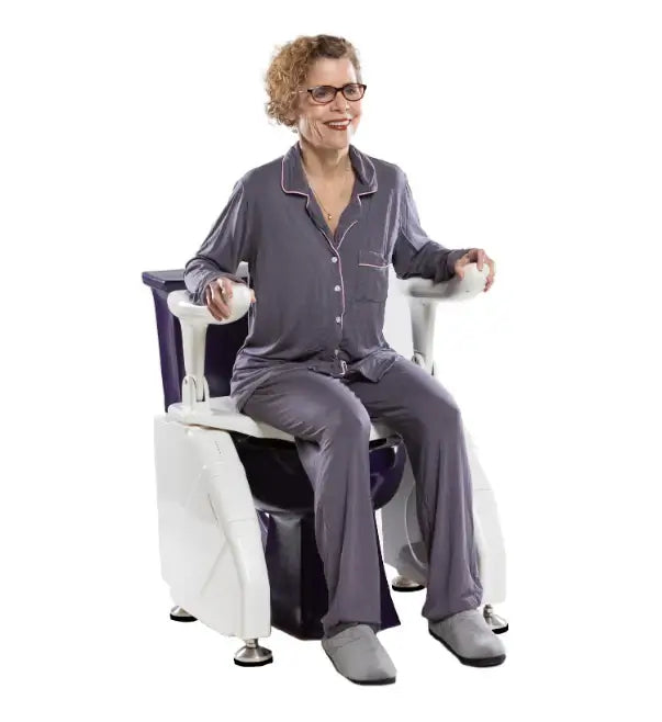 A woman smiling and sitting on the Allied Medical electric toilet lift seat, demonstrating ease of use and comfort.